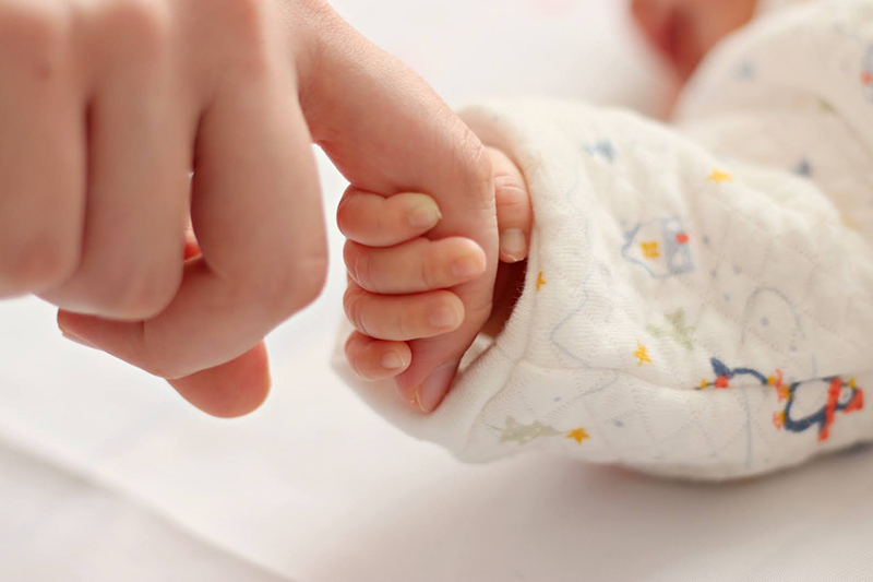 赤ちゃんと手を繋ぐ写真